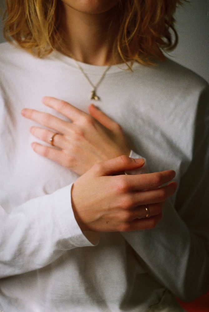 Woman's hands on chest, representing body-focused somatic therapy